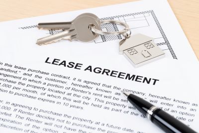 Generic lease agreement document with a house key and a pen on the table