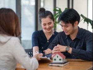 An asian couple doing paperwork at a business office.